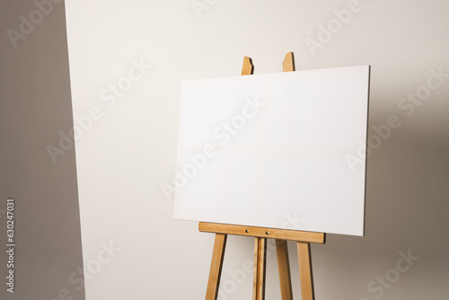 White canvas on wooden easel and copy space on white background