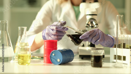 Slika na platnu Scientist in chemical industrial laboratory holds black liquid crude oil in flask