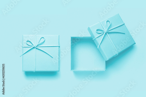 Top view of empty open gift box for congratulations on blue background. © fotomaximum