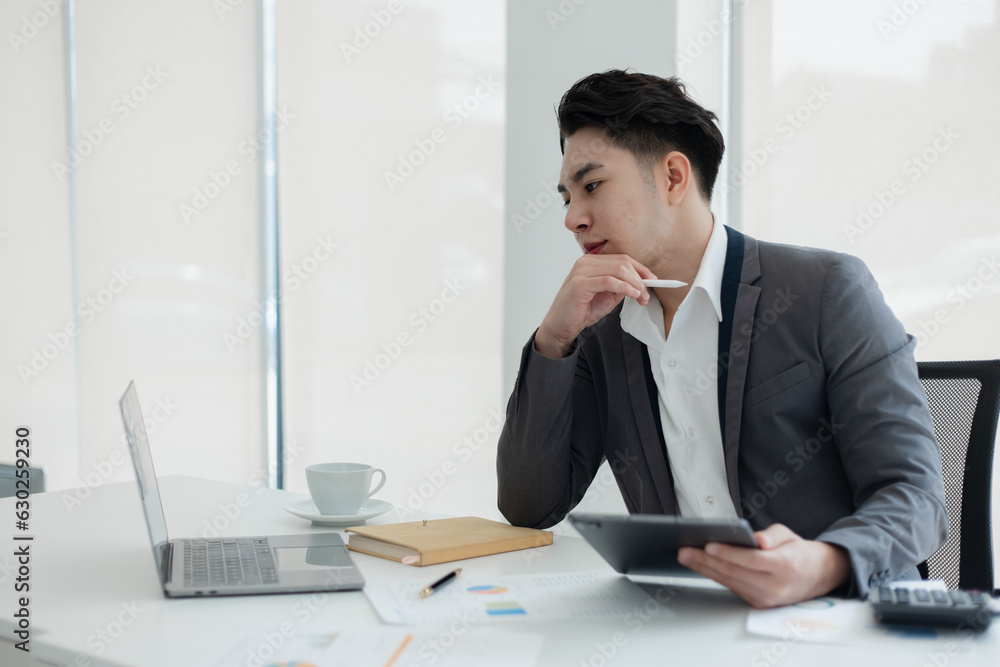 sad asian businessman sitting at desk in modern office, stressed man, problem, Worried young man businessman, sad asian businessman sitting at desk in modern office, stressed man, problem, Worried young man businessman,