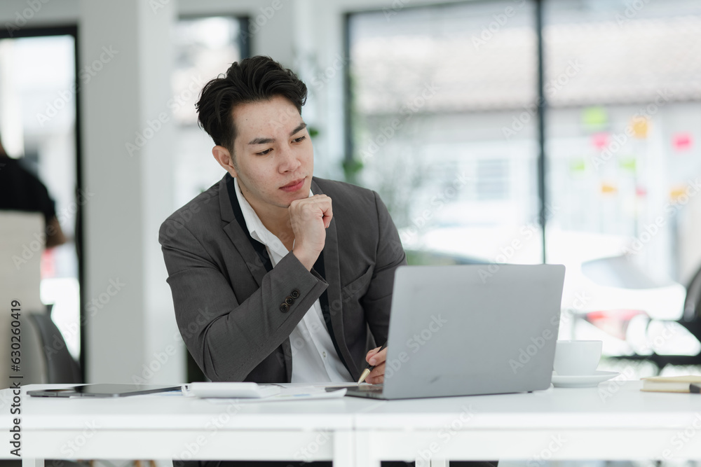 sad asian businessman sitting at desk in modern office, stressed man, problem, Worried young man businessman, 