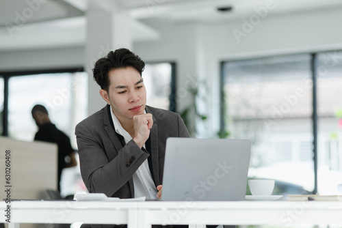 sad asian businessman sitting at desk in modern office, stressed man, problem, Worried young man businessman, 