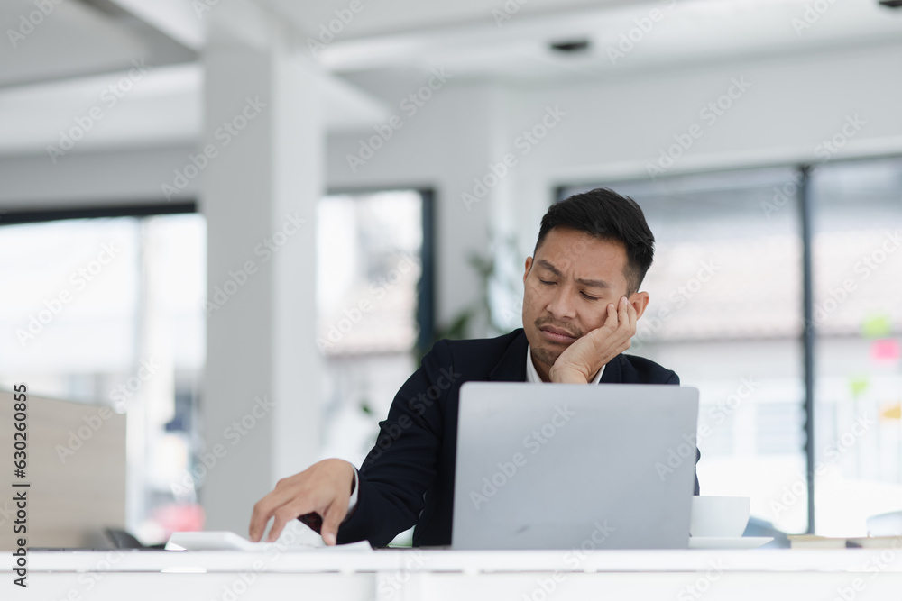sad asian businessman sitting at desk in modern office, stressed man, problem, Worried young man businessman, sad asian businessman sitting at desk in modern office, stressed man, problem, Worried young man businessman,