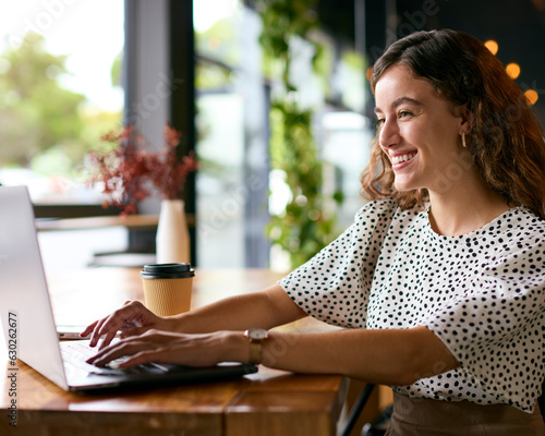 Young Businesswoman With Takeaway Coffee Working Sitting On Laptop In Coffee Shop Or Office