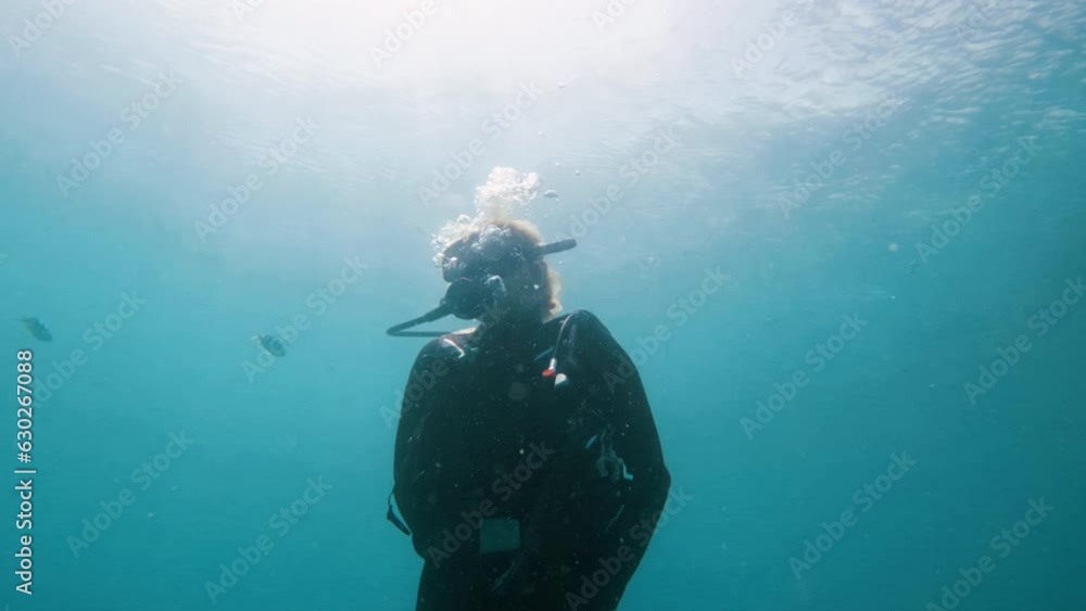 Scuba Diver Ascending to Surface with Bubbles and Great Reflection of Sun in Water Scuba Diver Ascending to Surface with Bubbles and Great Reflection of Sun in Water