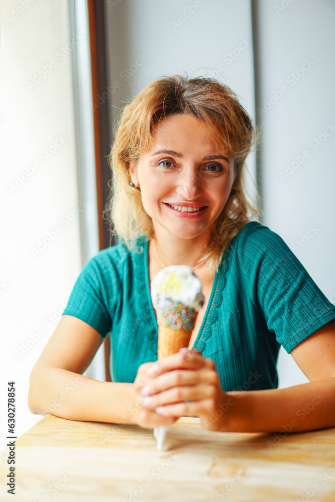 Beautiful happy woman hold ice cream in cafe and look in camera Beautiful happy woman hold ice cream in cafe and look in camera