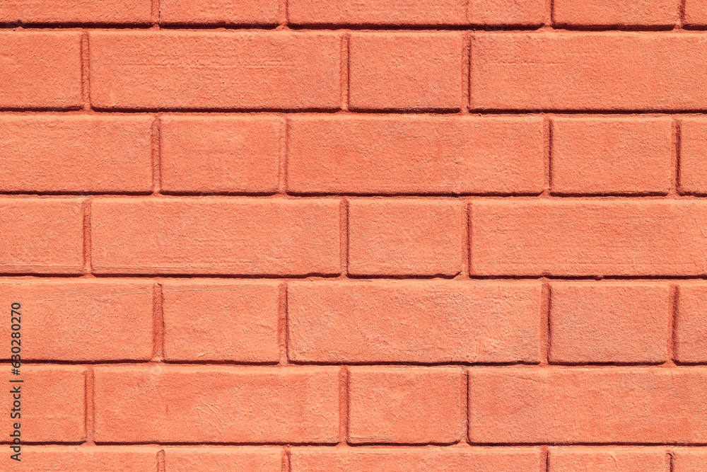 Texture of a brick wall coated with the thick layer of pastel orange ...
