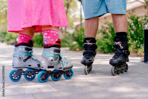 Close-up of the legs of a couple man and woman rollerblading in the park while on a date 