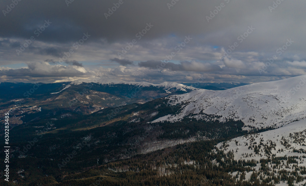 Sun rays illuminate the mountain valley. Location place ski resort Dragobrat, Carpathian, Ukraine, Europe. Splendid picture of winter journey. Great nature wallpapers. Aerial drone picture.