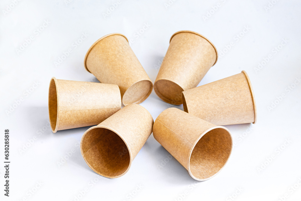 Fototapeta premium Stack of paper mugs. Six disposable paper cups made of cardboard kraft paper.