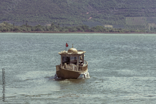 View of a characteristic boat sailing along the Ulubat Lake off Golyazi Merkez coastline, Bursa, Turkey. photo