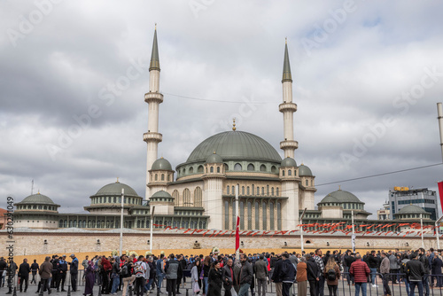 Istanbul, Turkey - 23 April 2023: View of a a group of people standing at Taksim square with Taskim mosque for Erdogan election in Istanbul. photo