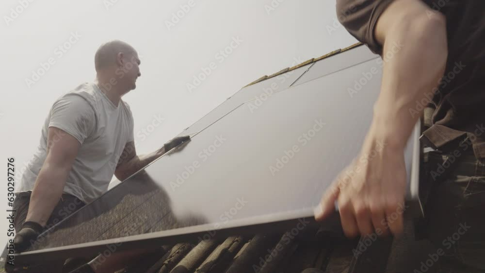 MS Technicians fitting solar photo voltaic panels to house roof MS Technicians fitting solar photo voltaic panels to house roof