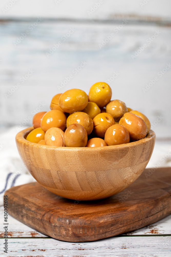 Big green olive at wooden bowl. Olives on a white wood background. Mediterranean food. vegan food Big green olive at wooden bowl. Olives on a white wood background. Mediterranean food. vegan food