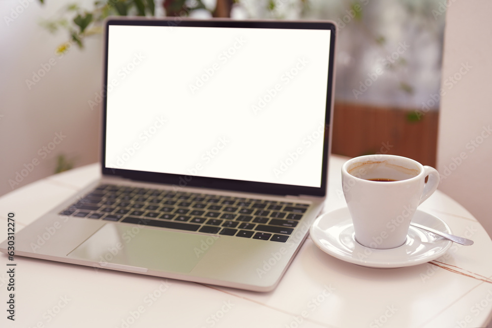 Blur laptop computer with blank white screen with coffee cup on white table background. Working business concept. Blur laptop computer with blank white screen with coffee cup on white table background. Working business concept.
