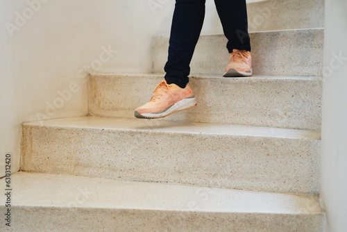 Going downstairs. Close up view of woman legs walking downstairs.
