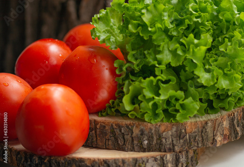 ripe tomatoes with water drops and lettuce leaves photo