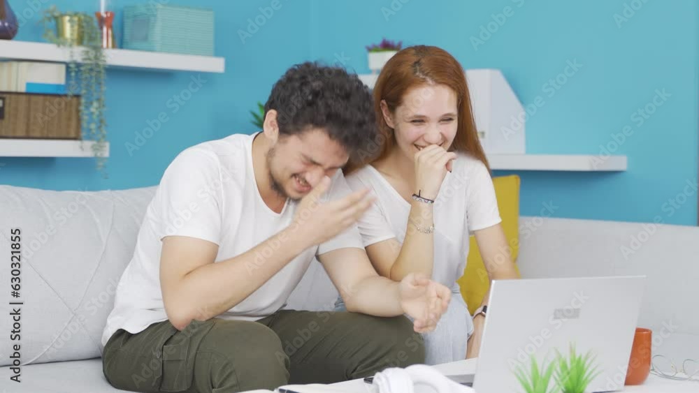 Couple watching comedy movie on laptop. They are having fun. Couple watching comedy movie on laptop. They are having fun.