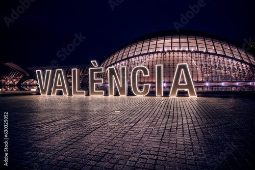 Illumianted Valencia neon sign in front of the Hemisferic building of the city of arts and sciences. photo