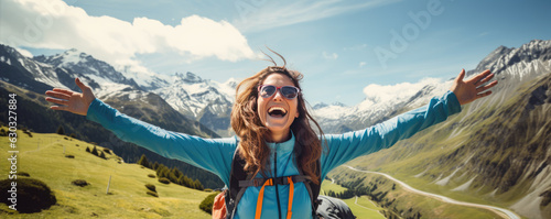 Happy woman with open arms on bike high in mountains.