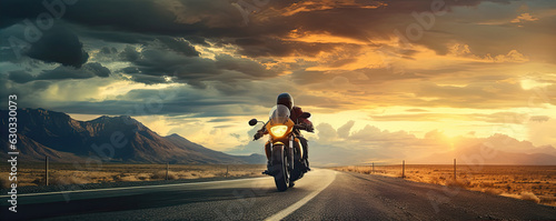 Driver riding motocycle on empty road in sunset light.  Panorama photo.