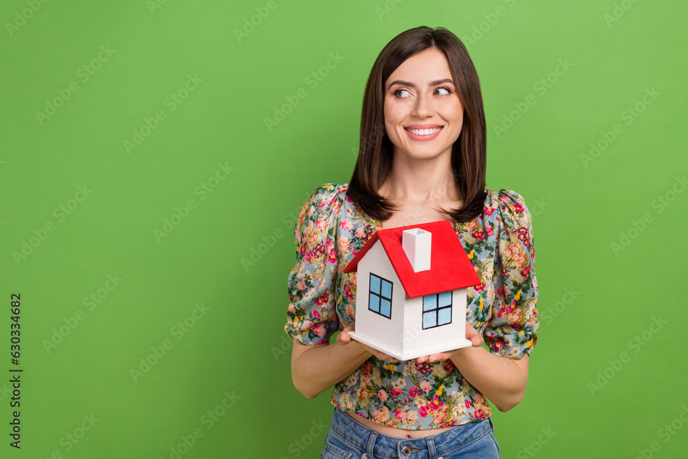 Photo of cute cheerful lady hands hold small house look empty space isolated on green color background