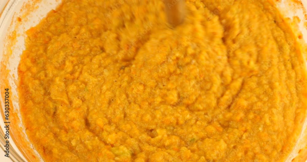 Stewed vegetables (carrots, onions, peppers and zucchini) are mixed until smooth in a glass bowl using an immersion blender. Preparing a vegetable snack. Stewed vegetables (carrots, onions, peppers and zucchini) are mixed until smooth in a glass bowl using an immersion blender. Preparing a vegetable snack.