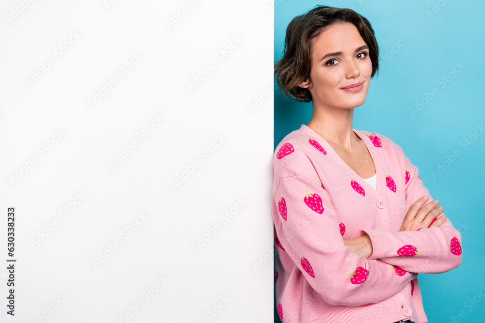 Photo of gorgeous positive girl crossed hands posing empty space ad placard offer isolated on blue color background Photo of gorgeous positive girl crossed hands posing empty space ad placard offer isolated on blue color background
