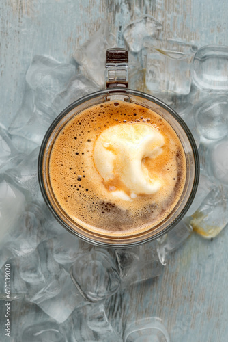 Affogato coffee with vanilla ice cream in a glass cup on wooden table photo