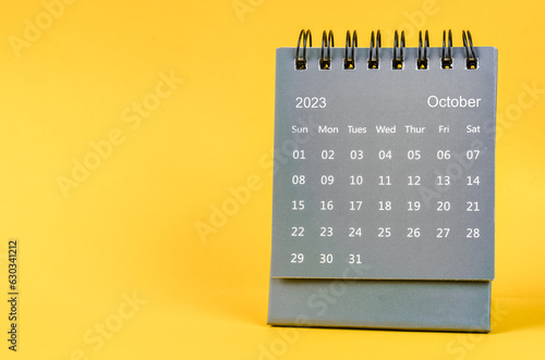 The October 2023 Monthly desk calendar for 2023 year on yellow background.