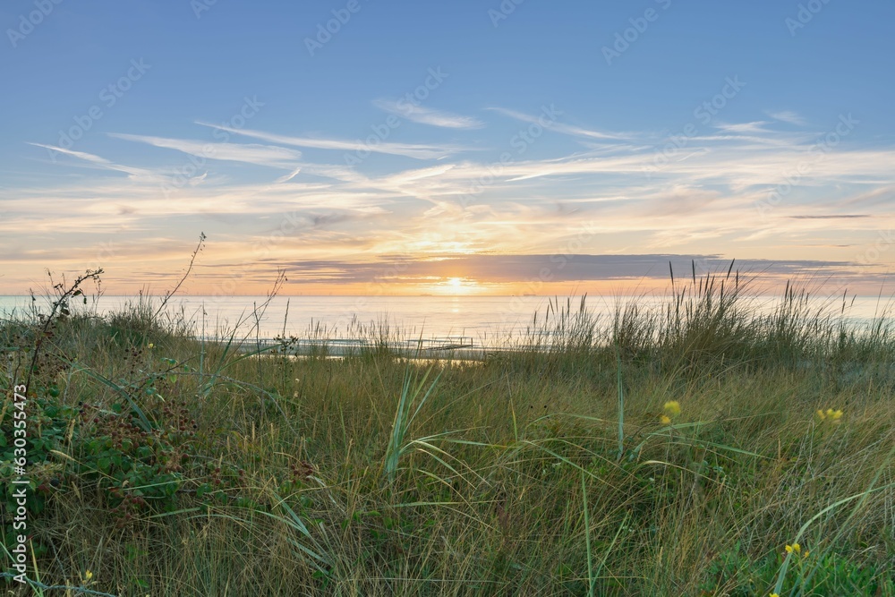 View from dune top over sundown at North Sea and canal in Zeelan