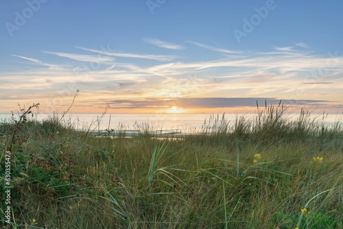 View from dune top over sundown at North Sea and canal in Zeelan