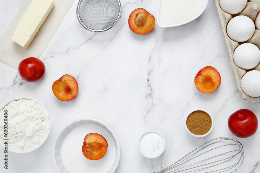 Ingredients for making classic cake pie with plums on white background. Concept homemade food, seasonal pastries. Top view, copy space Ingredients for making classic cake pie with plums on white background. Concept homemade food, seasonal pastries. Top view, copy space