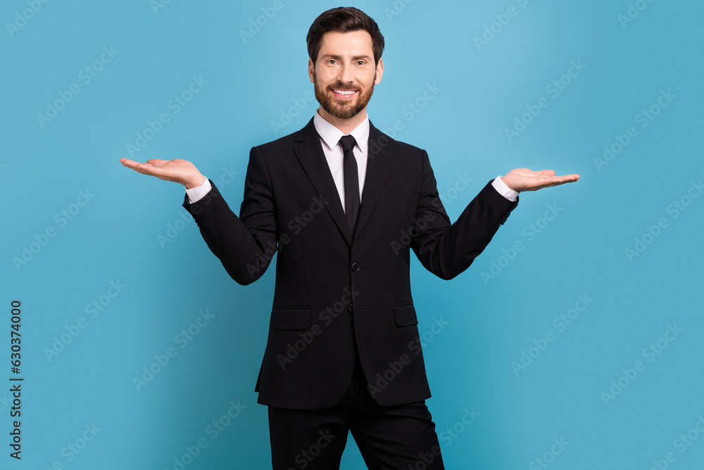 Photo of marketing promoter business guy wear stylish formal costume holding arms presentation products isolated on blue color background Photo of marketing promoter business guy wear stylish formal costume holding arms presentation products isolated on blue color background
