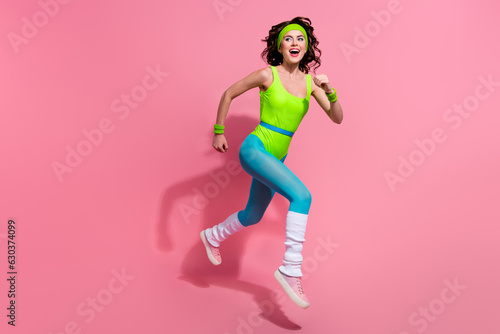 Fototapeta Naklejka Na Ścianę i Meble -  Photo of excited lady coach racing on marathon in jump winning isolated over pastel color background