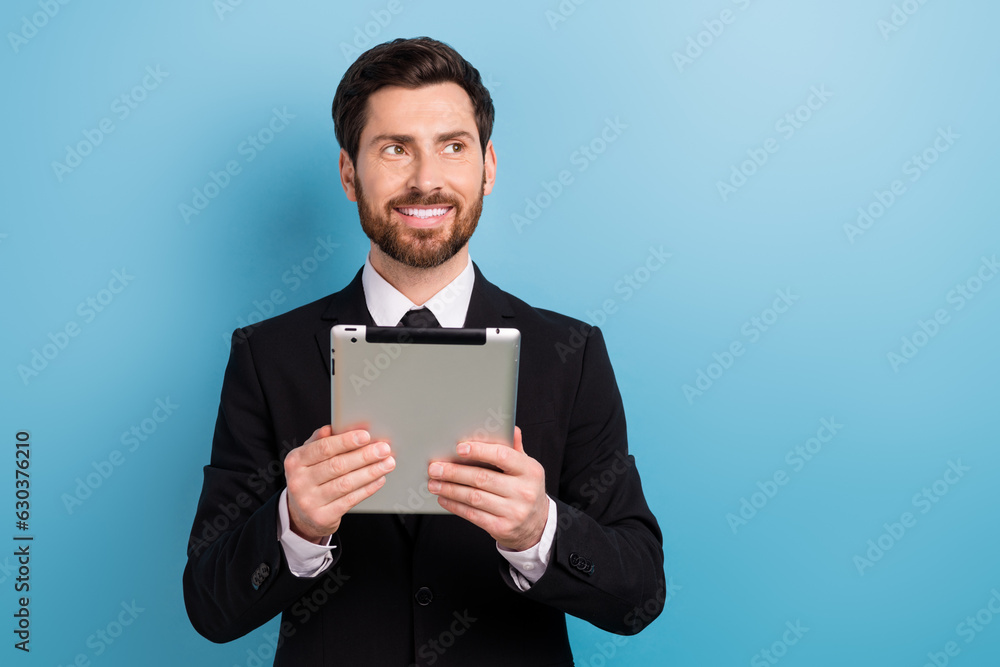 Photo of smiling dreamy lawyer wear black tuxedo texting modern device looking empty space isolated blue color background Photo of smiling dreamy lawyer wear black tuxedo texting modern device looking empty space isolated blue color background
