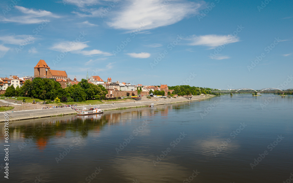 Panorama of Torun, old medieval town in Poland. Tourist boats on Vistula river with panorama of old town Torun in summer day.