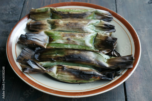 Otak-Otak is an Indonesian snack. The main ingredient of the dish is ground fish paste. Otak-otak is traditionally served steamed or grilled, encased within the leaf parcel it is cooked in. photo