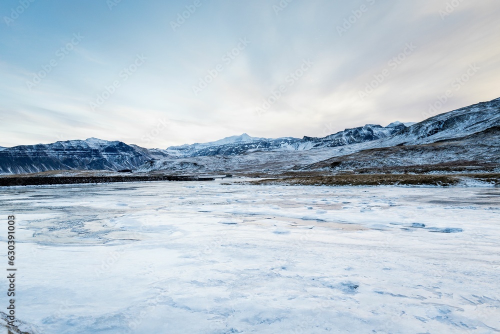 Majestic view of the snow-covered hills above a frozen river