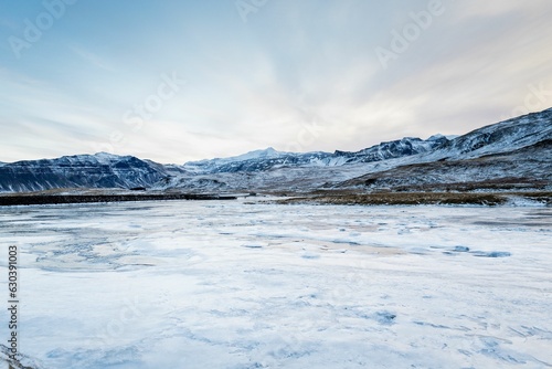 Majestic view of the snow-covered hills above a frozen river