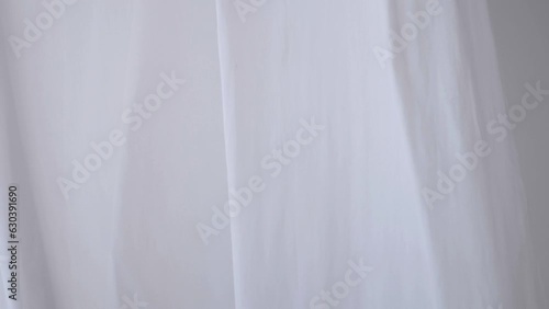 White transparent fabric flutters in the wind. Long white curtains in a bright studio. slow motion photo