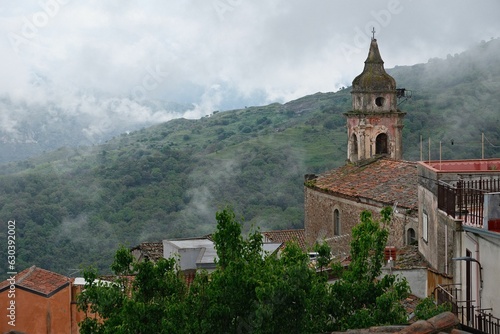 Castiglioni di Sicilia commune in Sicily with buildings surrounded by lush trees and clouds