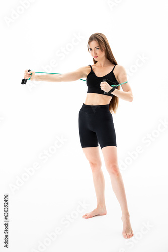 A beautiful girl in sportswear is training with an expander on a white background. Hand exercise © Andrei Pozharskiy