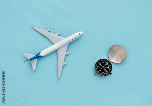Wall Mural A plane miniature and a compass isolated on blue background, after some edits