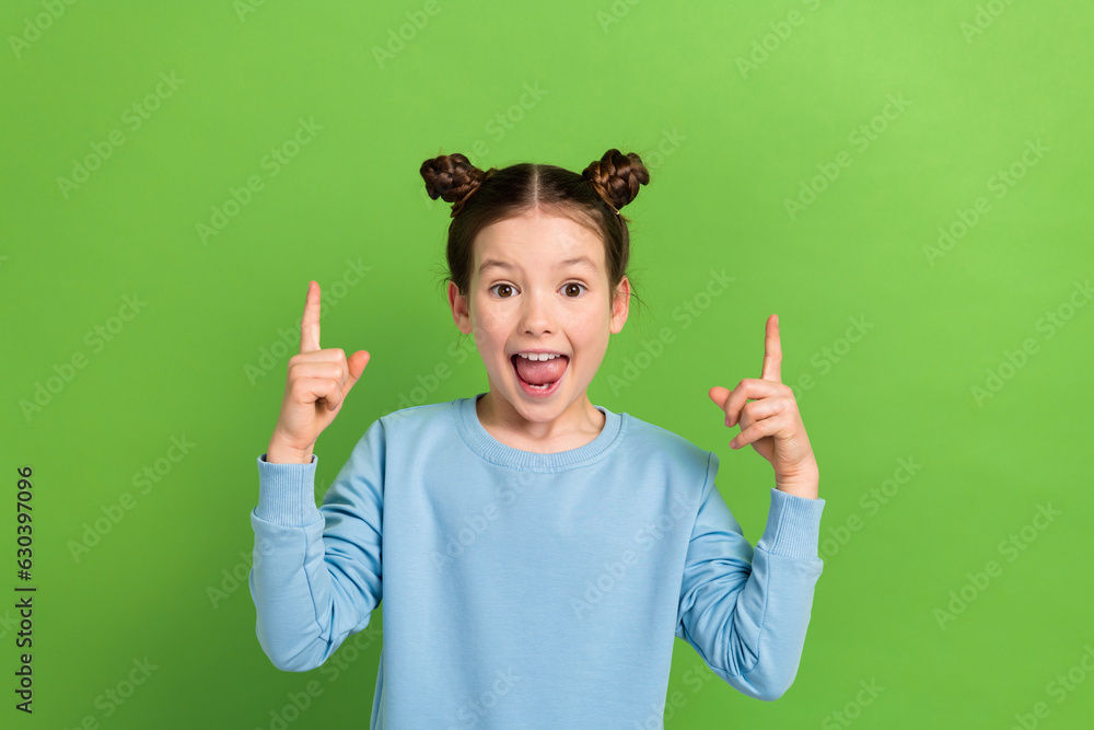 Photo of funny excited small girl wear blue casual shirt direct fingers up empty space ad ads adv isolated green color background Photo of funny excited small girl wear blue casual shirt direct fingers up empty space ad ads adv isolated green color background