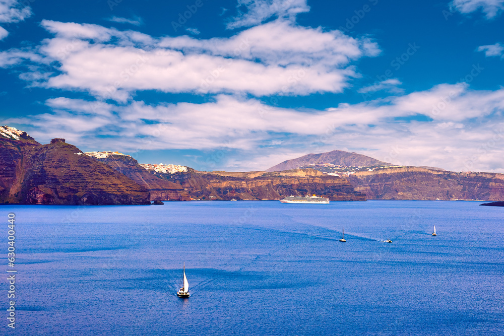 Panorama of Santorini, Greece, on sunny day, sailboats and white towns
