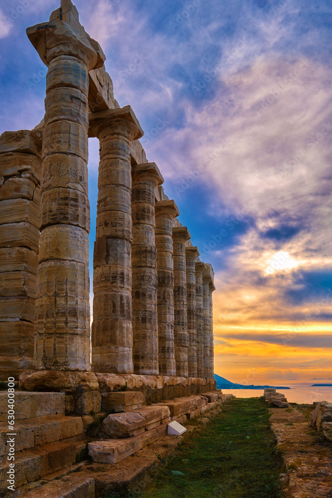 Sunset sky and ancient ruins of temple of Poseidon, Sounion, Greece
