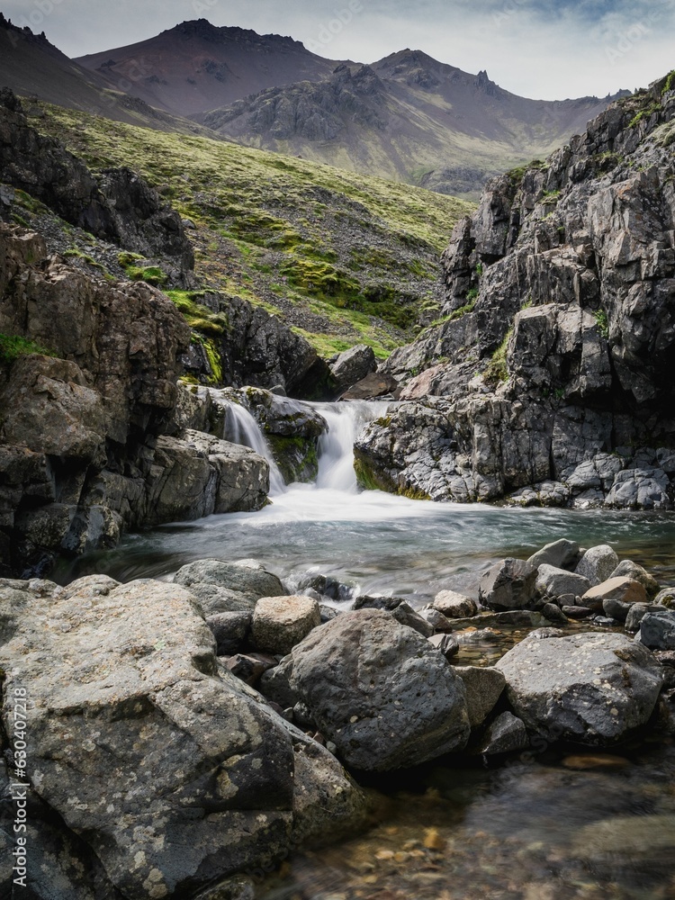 Vertical shot of a picturesque rocky waterfall in the East Fjords, Iceland