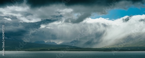Beautiful shot of large billowing clouds over a body of water in Iceland