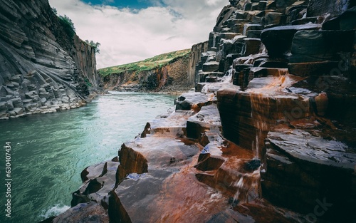 Closeup shot of water flowing over hexagonal rock formations in the Studlagil Canyon, Iceland